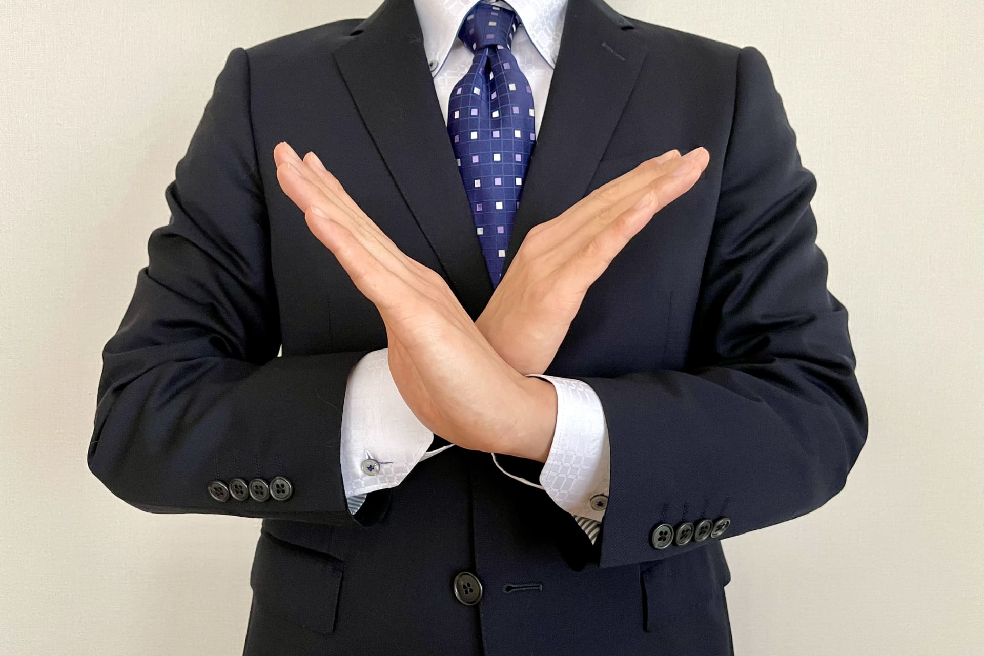 手でバツを表す男性