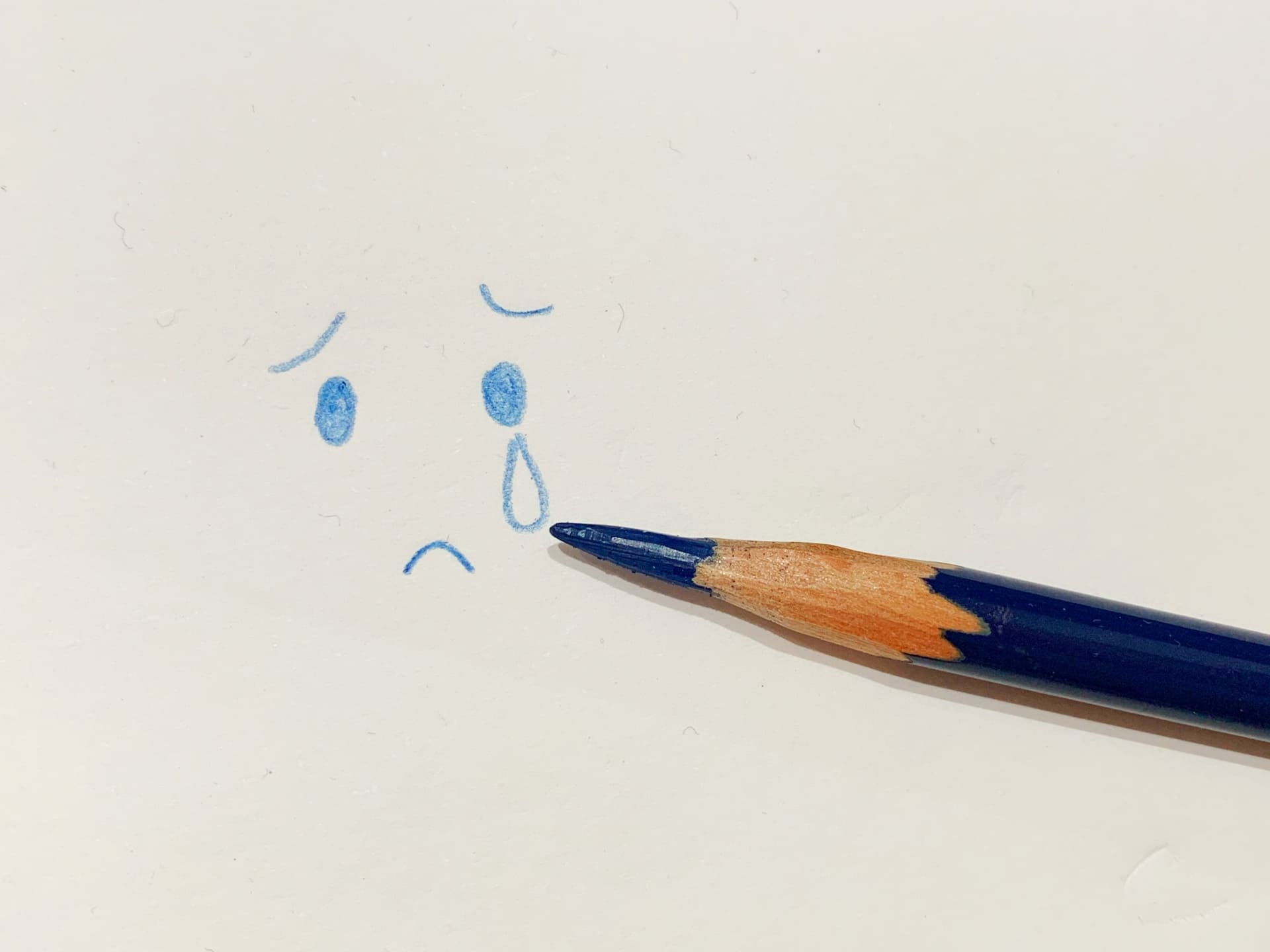 泣いている顔のイラストと色鉛筆